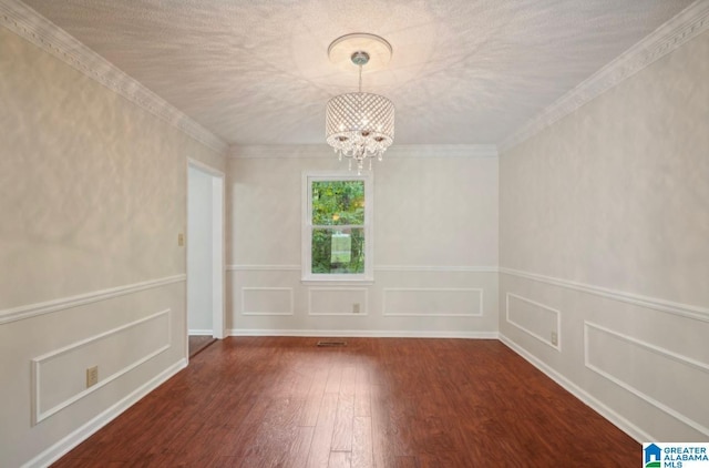 unfurnished room with wood-type flooring, a notable chandelier, and ornamental molding