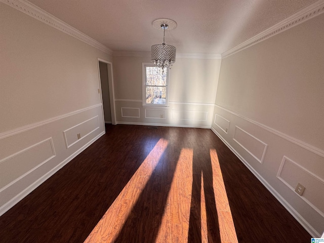 unfurnished dining area with dark hardwood / wood-style flooring, crown molding, and an inviting chandelier