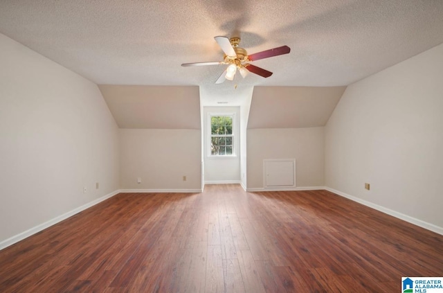 additional living space featuring ceiling fan, a textured ceiling, dark hardwood / wood-style flooring, and lofted ceiling