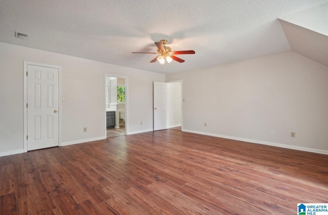 interior space featuring ceiling fan, lofted ceiling, a textured ceiling, and hardwood / wood-style floors