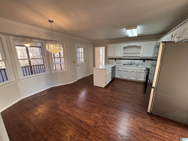 kitchen featuring white cabinets, appliances with stainless steel finishes, decorative light fixtures, tasteful backsplash, and a chandelier