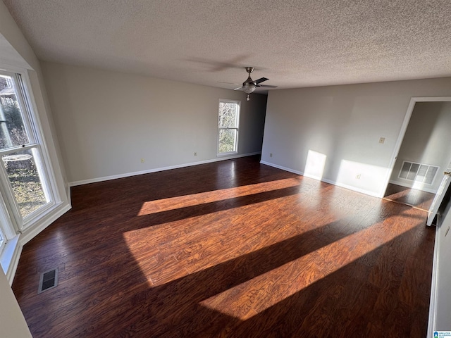 unfurnished room with ceiling fan, dark wood-type flooring, and a textured ceiling