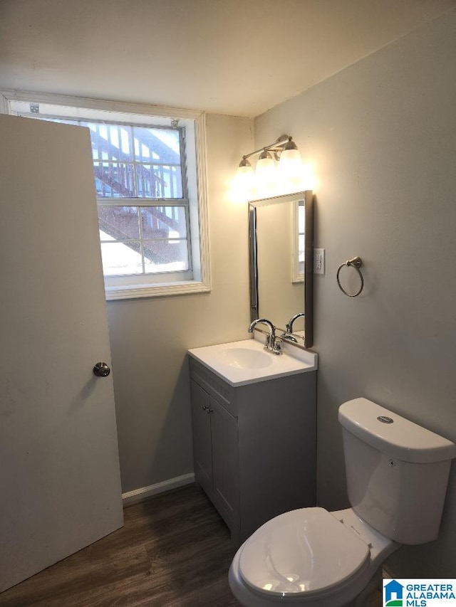 bathroom featuring hardwood / wood-style flooring, toilet, and vanity