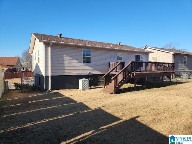 back of property featuring a lawn, a wooden deck, and central AC