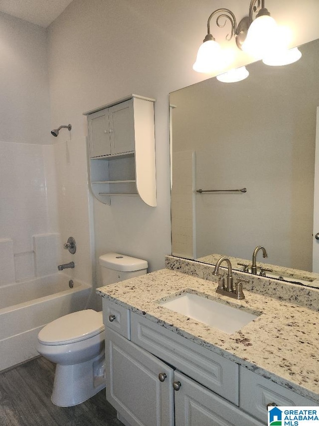 full bathroom with hardwood / wood-style floors, toilet, vanity, and shower / washtub combination