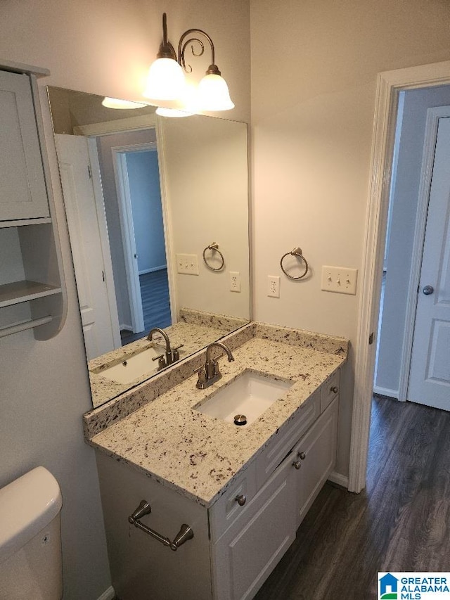 bathroom with wood-type flooring, toilet, and vanity