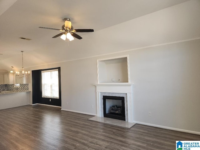 unfurnished living room with ceiling fan with notable chandelier and dark hardwood / wood-style floors