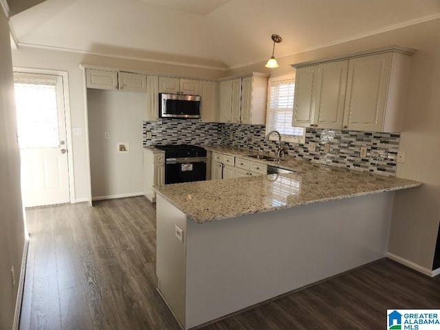 kitchen with black range oven, sink, hanging light fixtures, kitchen peninsula, and light stone counters