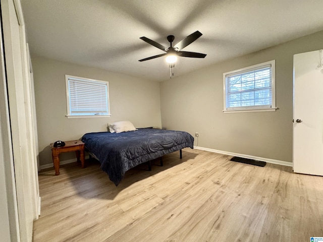 bedroom with ceiling fan and light hardwood / wood-style floors