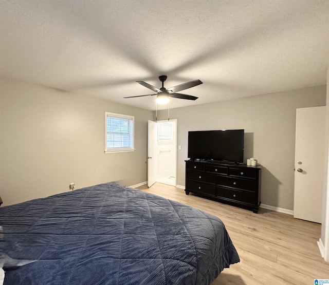 bedroom with ceiling fan, light hardwood / wood-style floors, and a textured ceiling