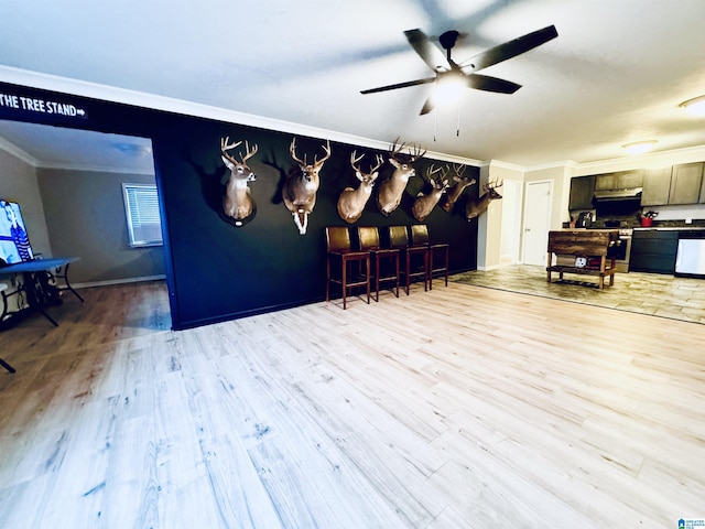 dining room with light wood-type flooring, ceiling fan, and ornamental molding