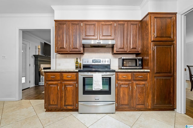 kitchen with light tile patterned floors, appliances with stainless steel finishes, and crown molding