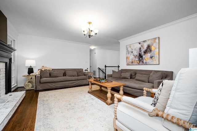 living room featuring an inviting chandelier, crown molding, a fireplace, and dark hardwood / wood-style floors