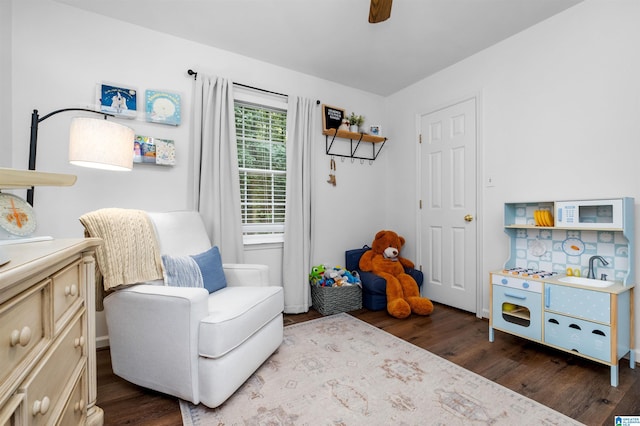 living area with ceiling fan and dark hardwood / wood-style flooring