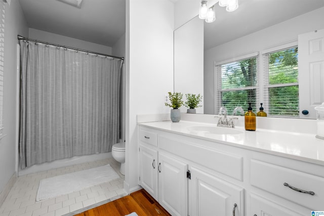 bathroom featuring toilet, vanity, and hardwood / wood-style flooring