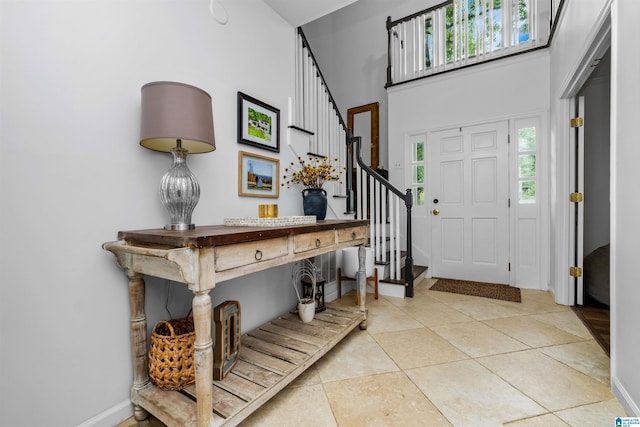 entrance foyer with a high ceiling and light tile patterned floors