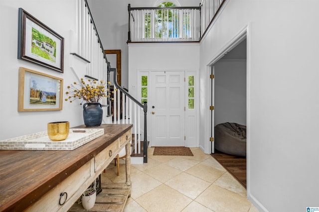 tiled foyer entrance featuring a towering ceiling and plenty of natural light