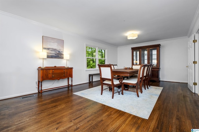 dining space with dark hardwood / wood-style flooring and ornamental molding