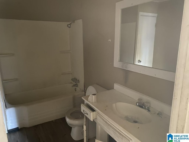 full bathroom with wood-type flooring, toilet, vanity, and shower / washtub combination