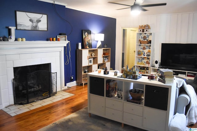 living room featuring ceiling fan, wood-type flooring, and a fireplace