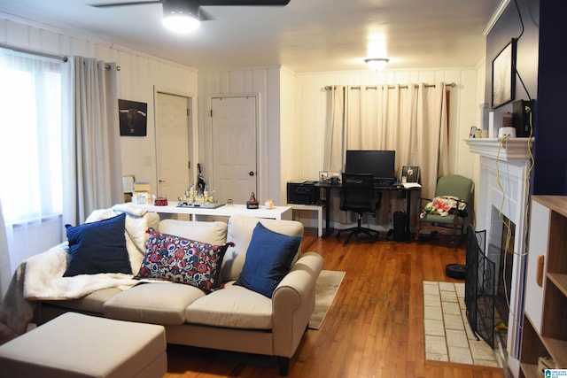 living room featuring ceiling fan, hardwood / wood-style floors, and a tile fireplace