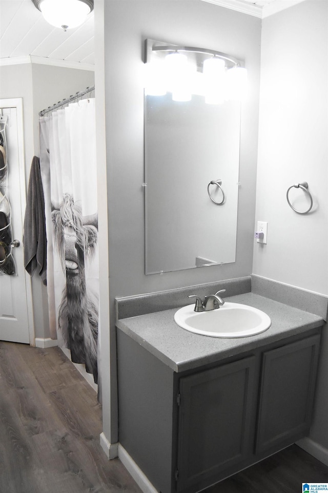 bathroom featuring ornamental molding, hardwood / wood-style floors, and vanity