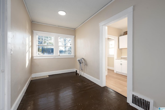 interior space featuring dark wood-type flooring and crown molding