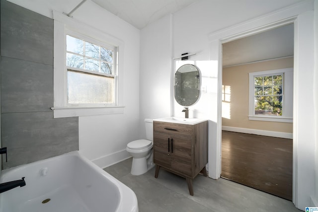 bathroom with vanity, toilet, and a tub