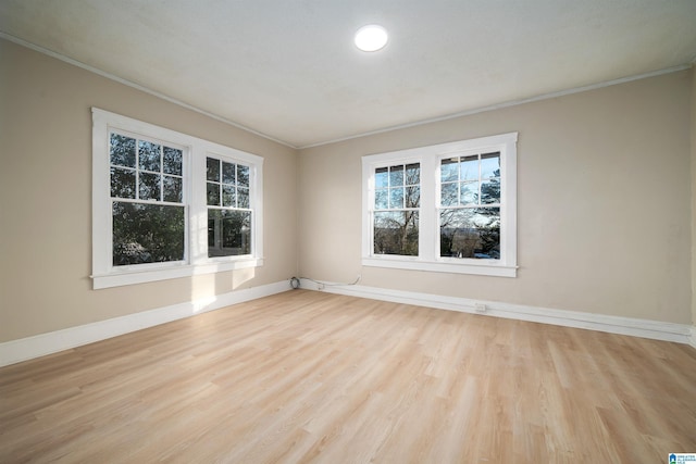 unfurnished room with light wood-type flooring and crown molding