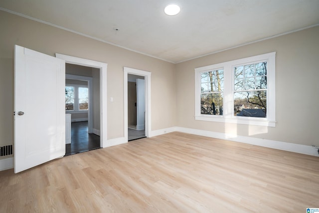 unfurnished bedroom with light wood-type flooring and ornamental molding