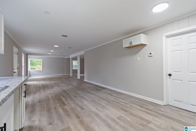 unfurnished living room featuring crown molding and light hardwood / wood-style flooring