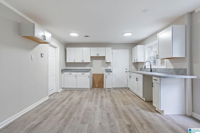 kitchen featuring sink, white cabinets, and light hardwood / wood-style flooring