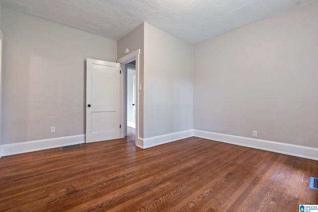 spare room with dark wood-type flooring