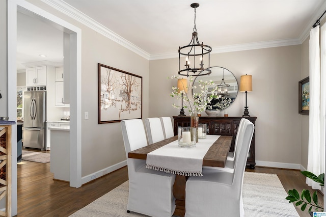 dining area with dark hardwood / wood-style flooring, crown molding, and a chandelier