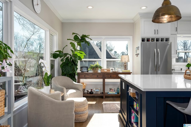 kitchen featuring dark hardwood / wood-style floors, stainless steel refrigerator, blue cabinetry, ornamental molding, and white cabinets