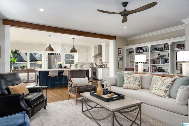 living room with light hardwood / wood-style floors, sink, crown molding, and ceiling fan