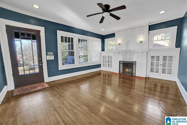 unfurnished living room with ceiling fan, crown molding, hardwood / wood-style flooring, and a brick fireplace