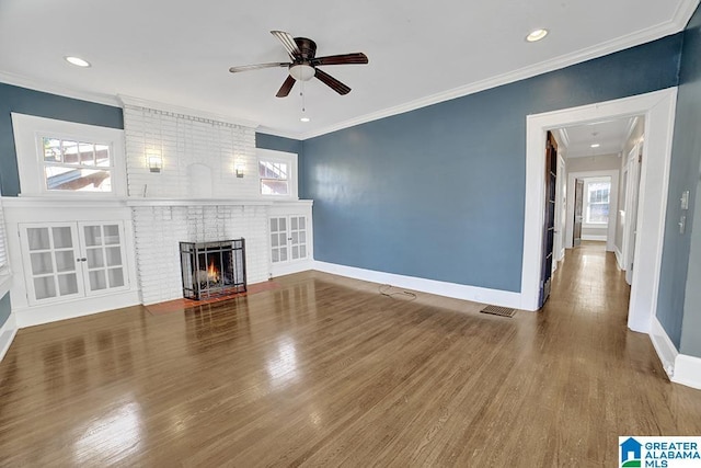 unfurnished living room with ceiling fan, a fireplace, ornamental molding, and hardwood / wood-style flooring