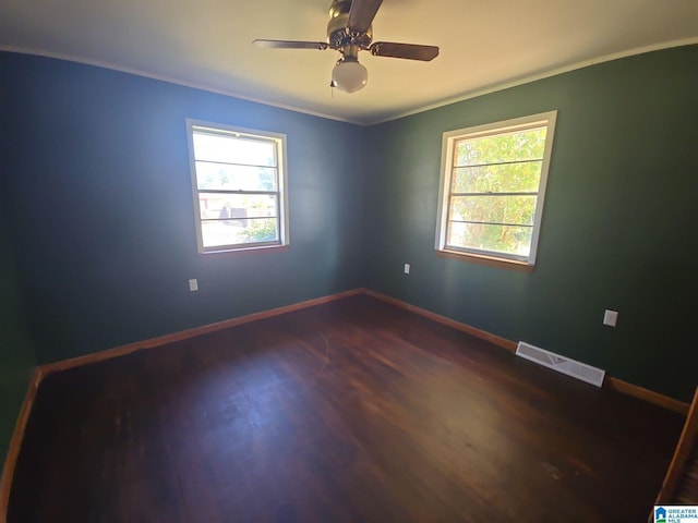 unfurnished room featuring ceiling fan, dark hardwood / wood-style flooring, and crown molding