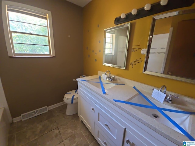 bathroom featuring tile patterned floors, toilet, and vanity