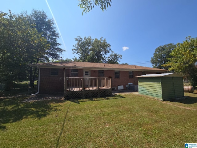 back of property featuring a storage shed, a wooden deck, and a yard