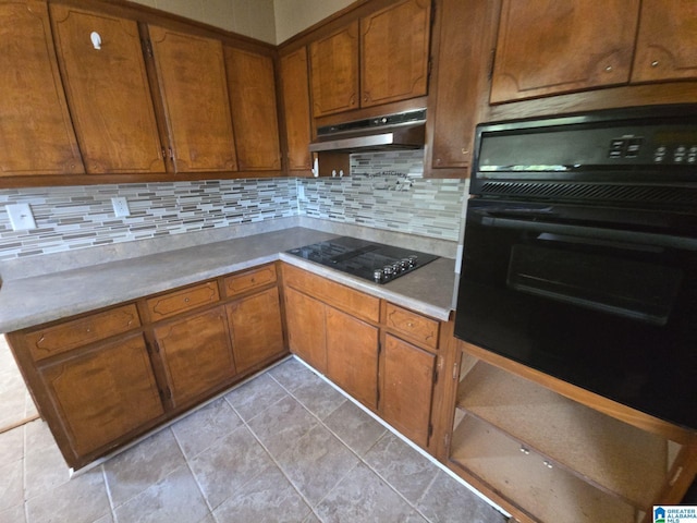 kitchen with light tile patterned floors, black appliances, and tasteful backsplash