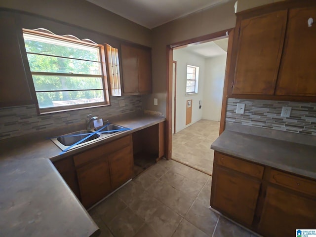 kitchen with decorative backsplash, tile patterned floors, and sink