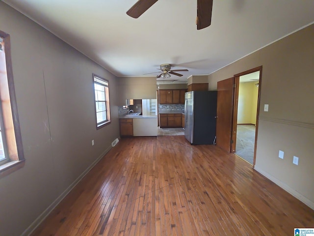 unfurnished living room featuring ceiling fan, dark hardwood / wood-style flooring, and sink