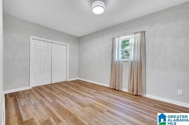 unfurnished bedroom with wood-type flooring and a closet