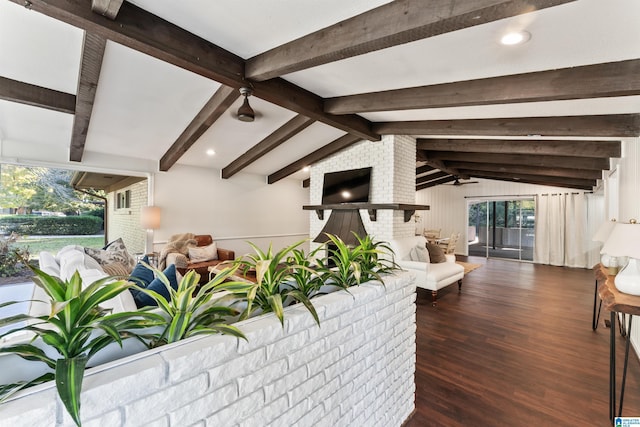 living room featuring a brick fireplace, plenty of natural light, dark wood-type flooring, and lofted ceiling with beams