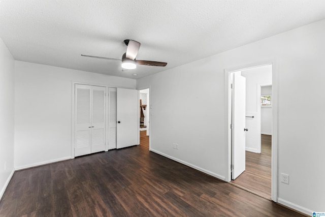 unfurnished bedroom featuring ceiling fan, a textured ceiling, dark hardwood / wood-style floors, and a closet