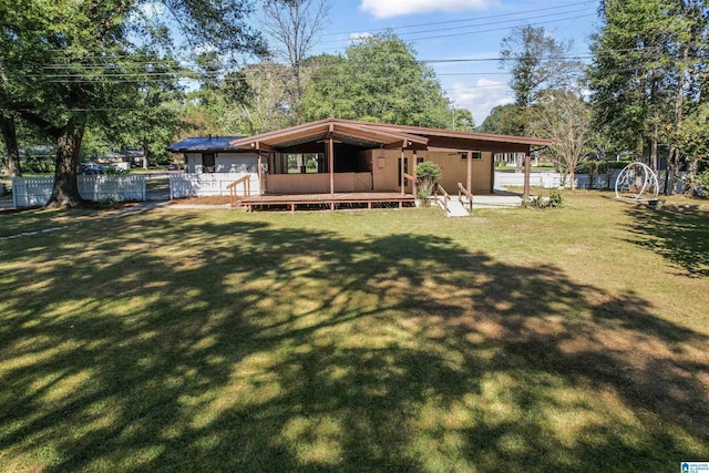 rear view of property featuring a lawn and a wooden deck