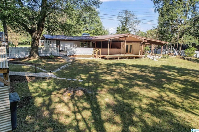 back of property featuring a wooden deck and a yard