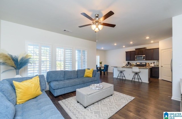 living room with ceiling fan and dark hardwood / wood-style flooring